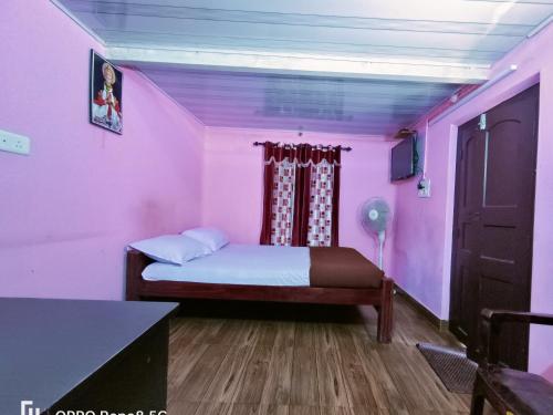 um quarto com uma cama num quarto cor-de-rosa em CAFFEE ISLAND FARM VILLA em Kaniyāmbetta