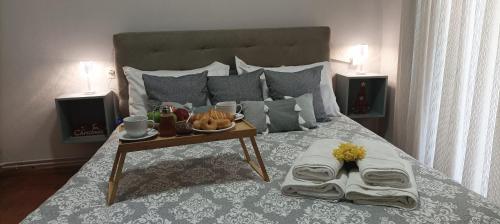 a bedroom with a bed with a tray of food on it at Volos Hospitality, Central Apartment in Volos