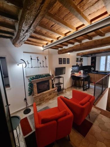 a living room with red chairs and a fireplace at OgniVolta in Pienza