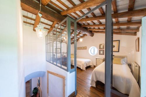 a bedroom with two beds in a room with wooden ceilings at Cortijo Chacón in Cazalla de la Sierra