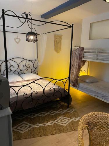 - une chambre avec un lit en fer forgé et des lits superposés dans l'établissement L'Auberge du Docteur Privey - Free & secure Park Bike - Voie Bleue, à Tournus