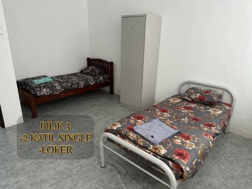 a bedroom with a bed and a small table with a bed sqor at ALUNAN HOMESTAY in Kangar