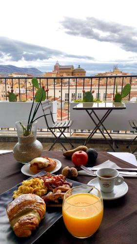 une table avec un plateau de nourriture et de jus d'orange dans l'établissement PALAZZO SANTAMARINA Luxury Suite & Spa, à Palerme