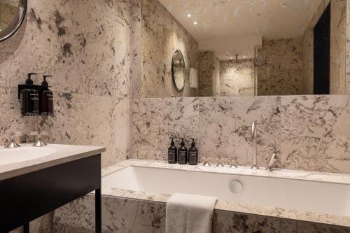 La salle de bains est pourvue d'une baignoire et d'un lavabo. dans l'établissement Hypernym Hotel & Suites, à Copenhague