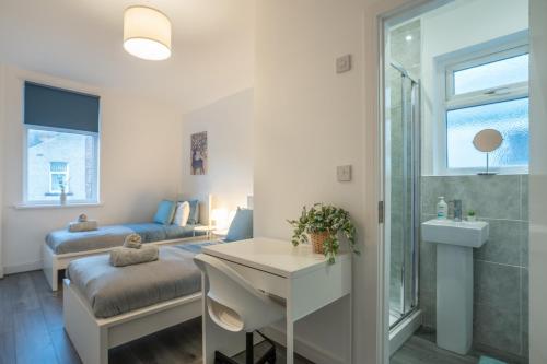 a room with a bed and a bathroom with a sink at Isimi luxurious 4 bed 4 en -suite house Cumbria in Barrow in Furness