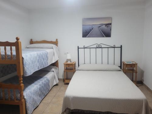 1 dormitorio con 2 camas y una foto en la pared en La Llar de Laura en El Poblenou del Delta