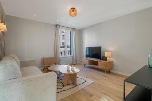 un salon avec un canapé et une télévision dans l'établissement 42.Appart 6Pers#2Bedroom #Père Lachaise #Nation, à Paris