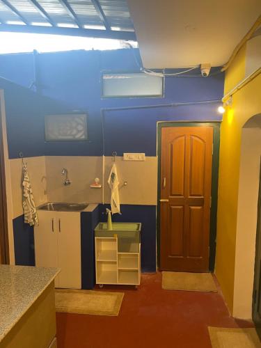 baño con paredes azules y puerta marrón en The Bungalow, en Bangalore