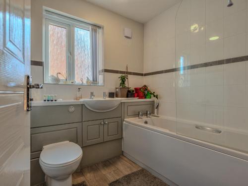 e bagno con servizi igienici, vasca e lavandino. di Lovely Detached Home Pass The Keys a Telford