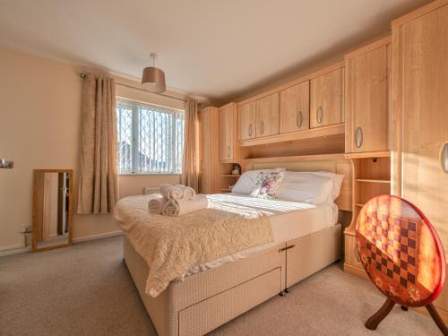 um quarto com uma cama grande e armários de madeira em Lovely Detached Home Pass The Keys em Telford