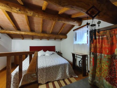 a bedroom with a bed in a room with wooden ceilings at La casina rossa della fornace in Cutigliano