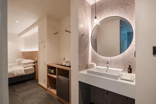 uma casa de banho com um lavatório e um espelho em ZEN MASTER HOTEL em Bangkok