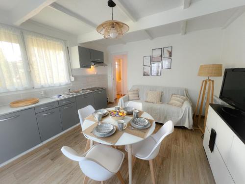een keuken en een woonkamer met een tafel en stoelen bij Le Côtier in Blériot-Plage