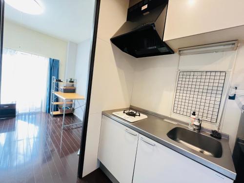 a small kitchen with a sink and a counter at 20 mins Direct to Ueno 21 mins to Ikebukuro Max for 3 peole Nishikawaguchi302 in Kawaguchi