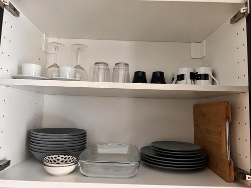 a pantry with plates and dishes on shelves at Lovely 1-Bed Apartment in Koblenz in Koblenz