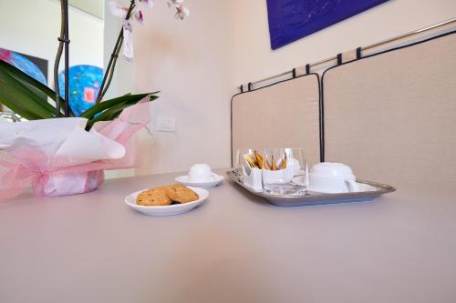 a table with a bowl of cookies and a tray of cups at La Villa in Novara