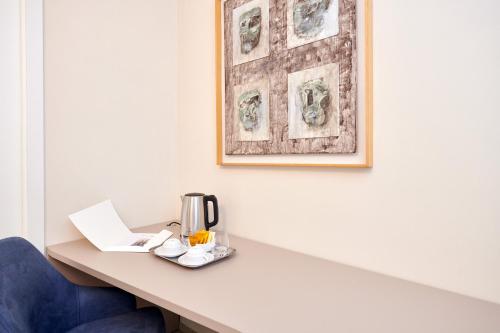 a hotel room table with a coffee maker and a picture at La Villa in Novara