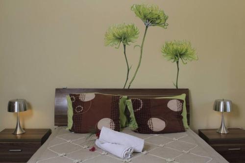 a bedroom with a bed with two flowers on the wall at Villa Fayette Sur Mer in Post of Flacq