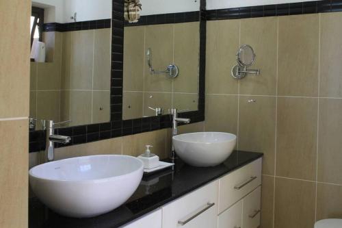 ein Badezimmer mit zwei Waschbecken und einem großen Spiegel in der Unterkunft Villa Fayette Sur Mer in Post of Flacq