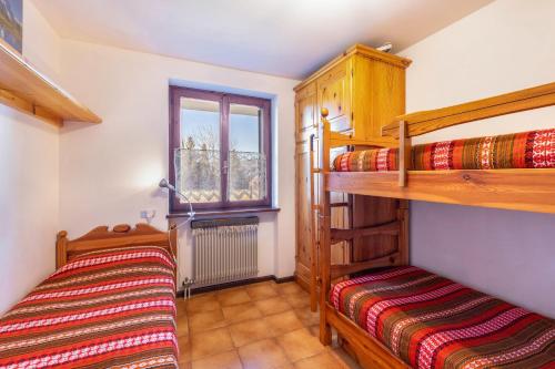 1 dormitorio con 2 literas y ventana en Lagorai 16 Villaggio Veronza, en Carano