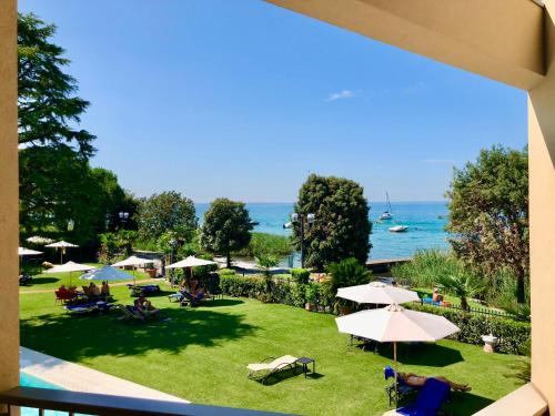 a view of a park with umbrellas and the ocean at Hotel Campagnola in Bardolino