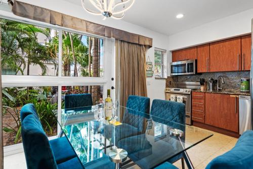 a dining room with a glass table and blue chairs at Isle of Venice Residence and Marina in Fort Lauderdale