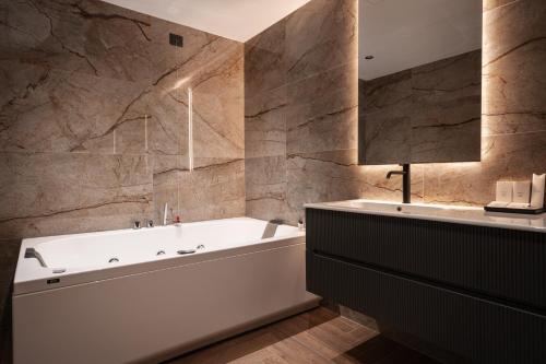 ein Badezimmer mit einer weißen Badewanne und einem Waschbecken in der Unterkunft Mood Hotel in Città Sant'Angelo