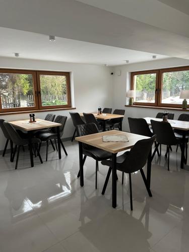 a dining room with tables and chairs and windows at Rozetka Białka in Białka Tatrzanska