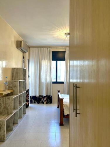 un couloir avec une chambre dotée d'une table et d'une fenêtre dans l'établissement Holikeys - Rabat - 1 Ch - Agdal 002, à Rabat