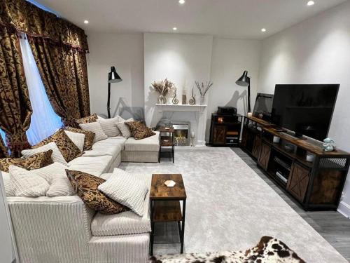 a living room with a white couch and a tv at Amazing 1 Bedroom Flat in Croydon