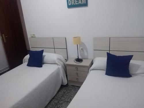 two beds with blue pillows in a bedroom at Apartamento Delicia in Belmonte