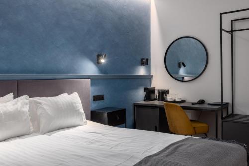 um quarto com uma cama e uma secretária com um espelho em Konventa Sēta Hotel Keystone Collection em Riga