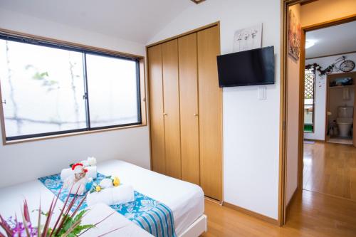 a small room with a bed and a tv at 東京吉久花園旅館 in Tokyo