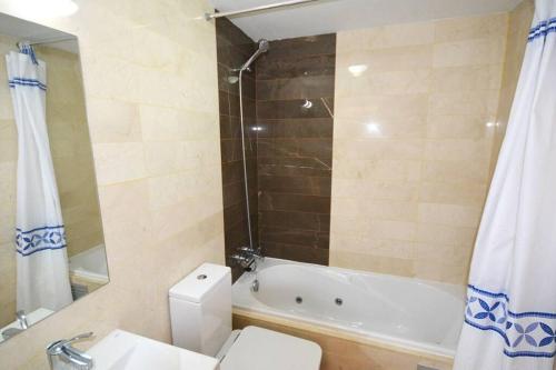 uma casa de banho com uma banheira, um WC e um lavatório. em Superb Penthouse in Central Fuengirola em Fuengirola