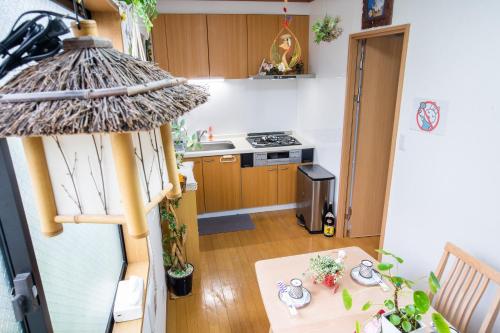 Il comprend une petite cuisine équipée d'une table, d'un évier et d'une cuisinière. dans l'établissement 東京吉久花園旅館, à Tokyo