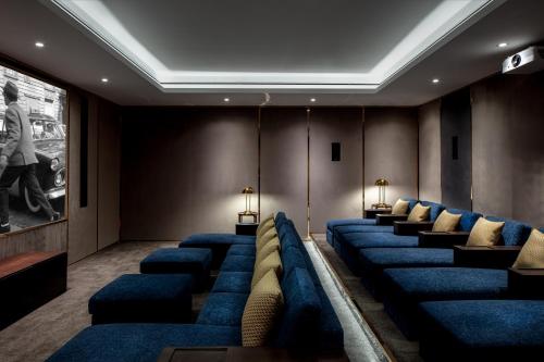 una sala de espera con sillas azules y una pintura en The Biltmore Hotel Villas, en Dubái