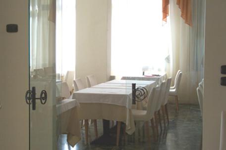 a dining room with a white table and chairs at Hotel Europa in San Bartolomeo al Mare