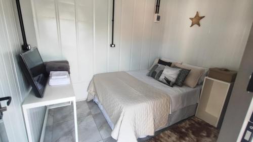 Dormitorio pequeño con cama y TV en Praia da vieira, en Porto Belo
