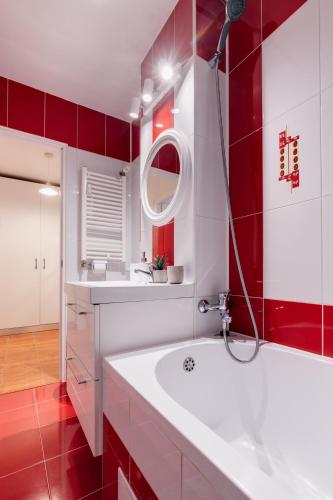 a bathroom with a white tub and a red wall at Perfect Stay CIPARIU in Cluj-Napoca