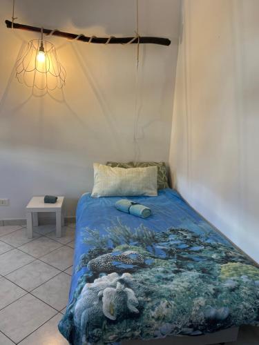 a bed with a blue comforter in a room at AppArt 24 city center parking and Sea in Lignano Sabbiadoro