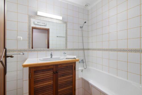 ein Badezimmer mit einem Waschbecken, einem Spiegel und einer Badewanne in der Unterkunft Estrela do mar in Santa Luzia