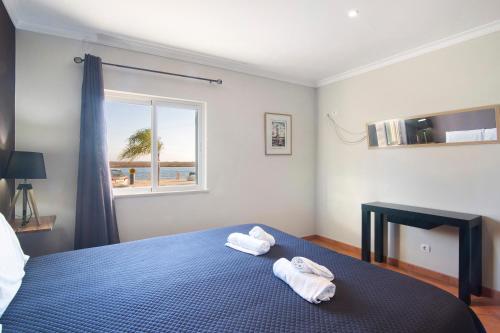 ein Schlafzimmer mit einem blauen Bett und Handtüchern darauf in der Unterkunft Estrela do mar in Santa Luzia