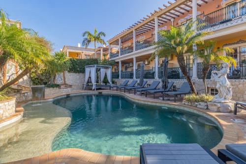 ラゴスにあるCharming Residence & Guest House Dom Manuel I Adults onlyの椅子と建物のあるプール