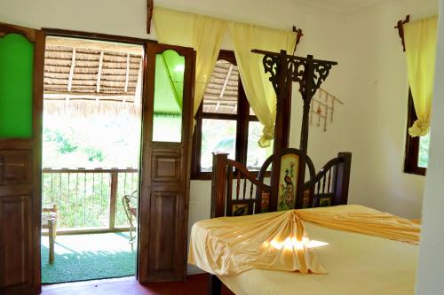 a bedroom with a bed and a large window at Embe Lodge in Kizimkazi