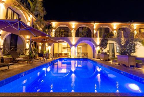 een zwembad voor een gebouw 's nachts bij BISABO SUITES APARTMENT LTD in Kigali