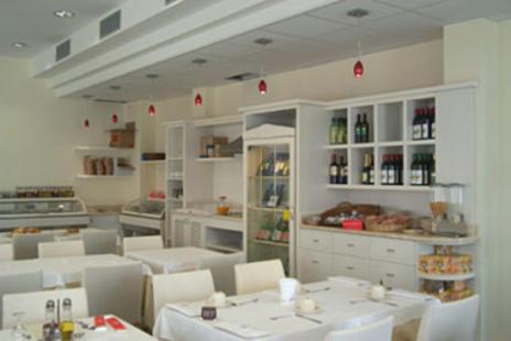 a dining room with white tables and white chairs at Hotel Europa in San Bartolomeo al Mare