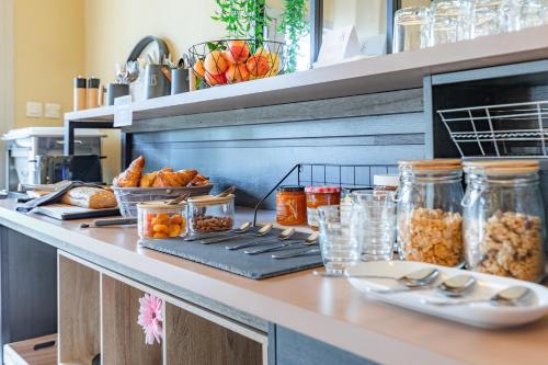 - un comptoir de cuisine avec du pain et des pots de nourriture dans l'établissement Appart'City Classic Toulouse Saint-Simon, à Toulouse