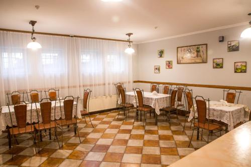 un comedor con mesas y sillas en un suelo a cuadros en Hotel Europa, en Truskavets