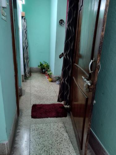 a hallway with a door with a red rug on the floor at Aasiyana in Bhubaneshwar