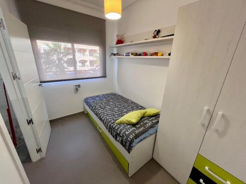 a small room with a bed in a room with a window at Modern and Stylish Apartament sea ​​views in Guardamar del Segura